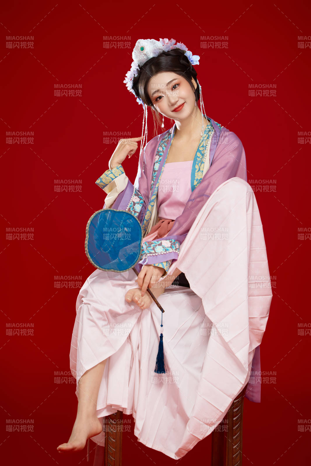 红色背景下身穿中国明朝簪花发饰汉服的美女图片