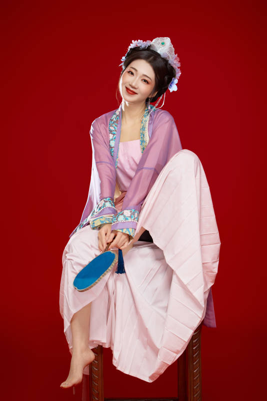 红色背景下身穿中国明朝簪花发饰汉服的美女图片