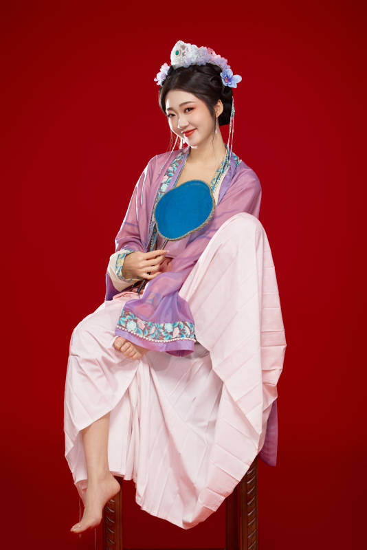 红色背景下身穿中国明朝簪花发饰汉服的美女图片