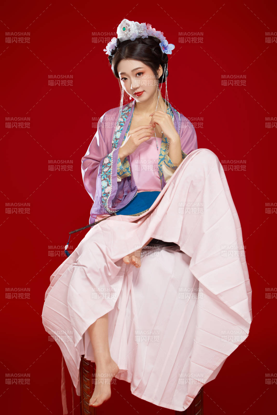 红色背景下身穿中国明朝簪花发饰汉服的美女图片