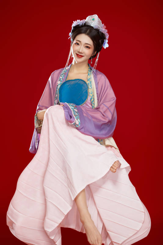 红色背景下身穿中国明朝簪花发饰汉服的美女图片