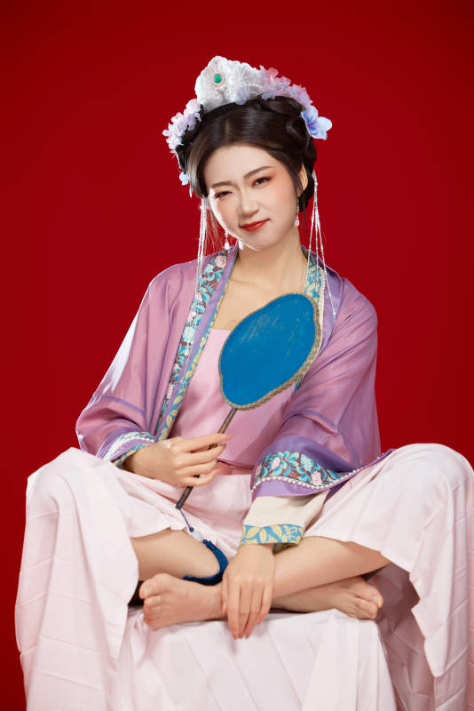 红色背景下身穿中国明朝簪花发饰汉服的美女图片