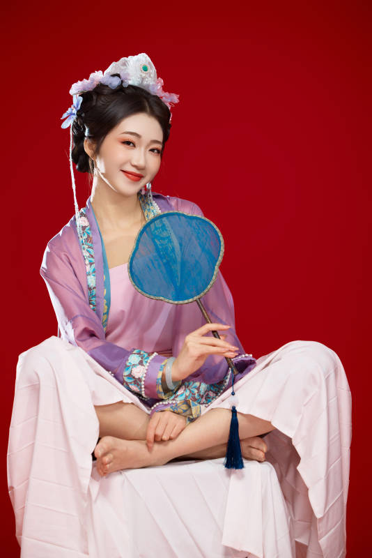 红色背景下身穿中国明朝簪花发饰汉服的美女图片