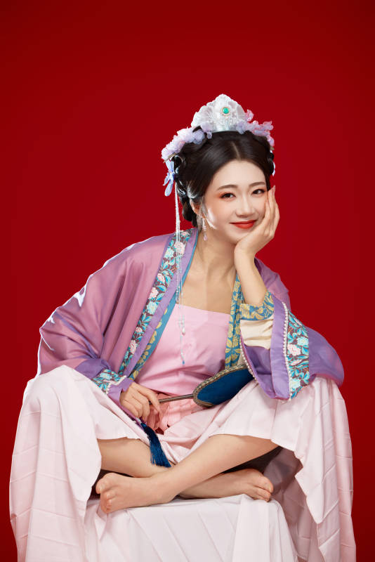 红色背景下身穿中国明朝簪花发饰汉服的美女图片