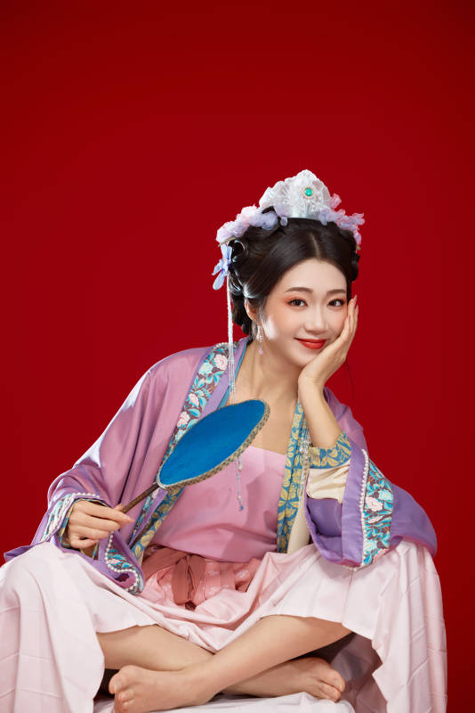 红色背景下身穿中国明朝簪花发饰汉服的美女图片