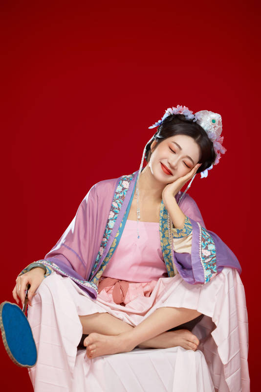 红色背景下身穿中国明朝簪花发饰汉服的美女图片