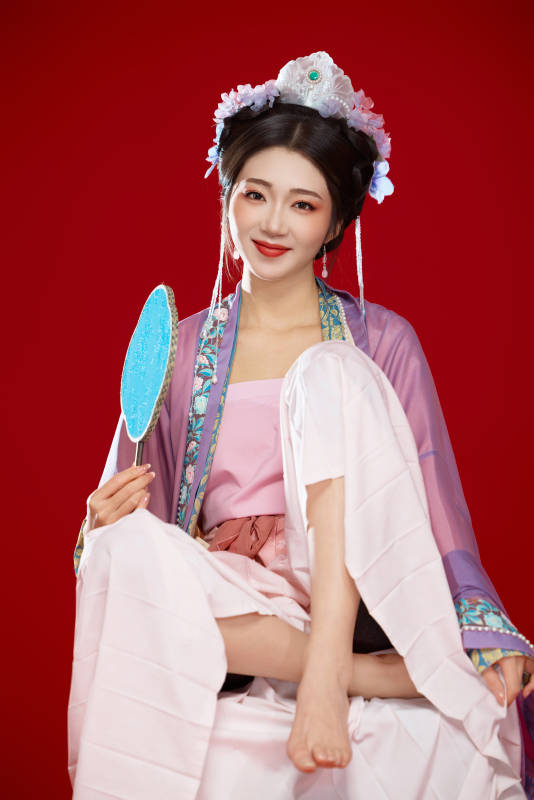 红色背景下身穿中国明朝簪花发饰汉服的美女图片