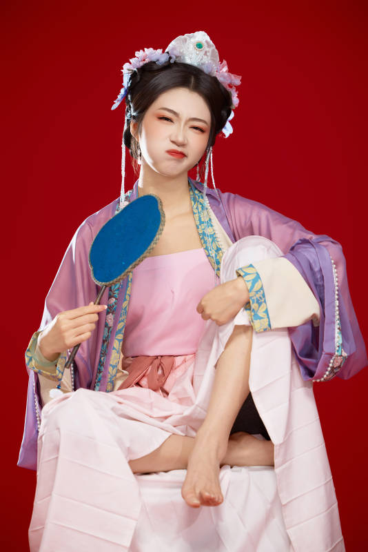 红色背景下身穿中国明朝簪花发饰汉服的美女图片