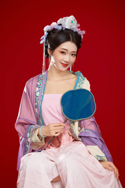 红色背景下身穿中国明朝簪花发饰汉服的美女图片