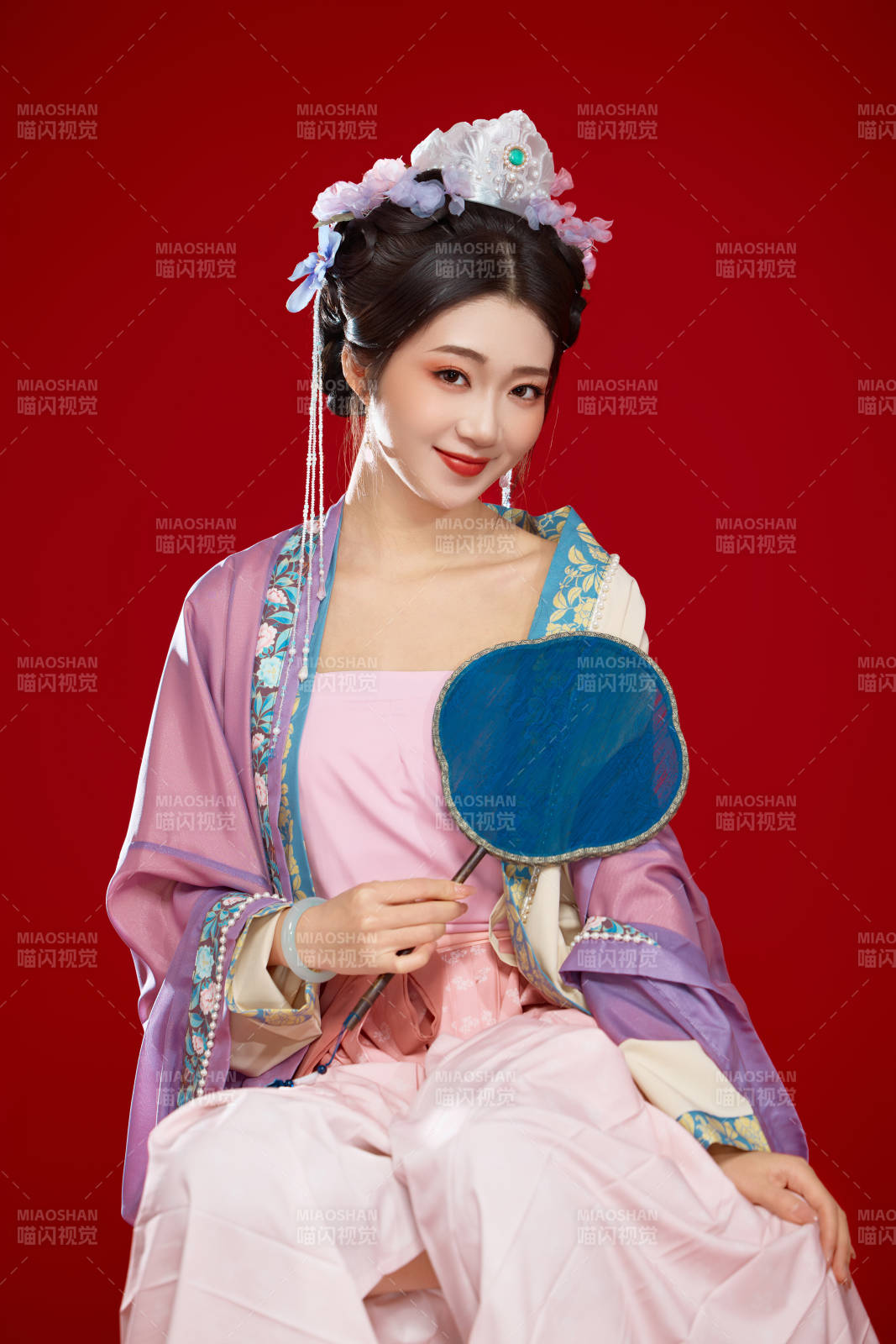 红色背景下身穿中国明朝簪花发饰汉服的美女图片