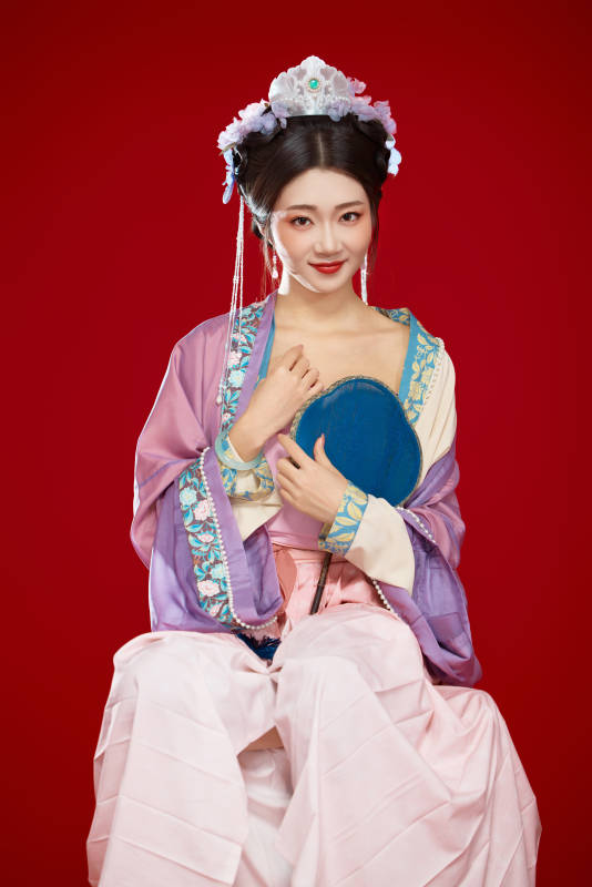 红色背景下身穿中国明朝簪花发饰汉服的美女图片