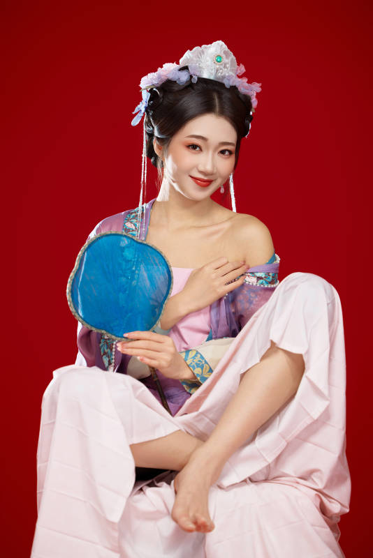 红色背景下身穿中国明朝簪花发饰汉服的美女图片
