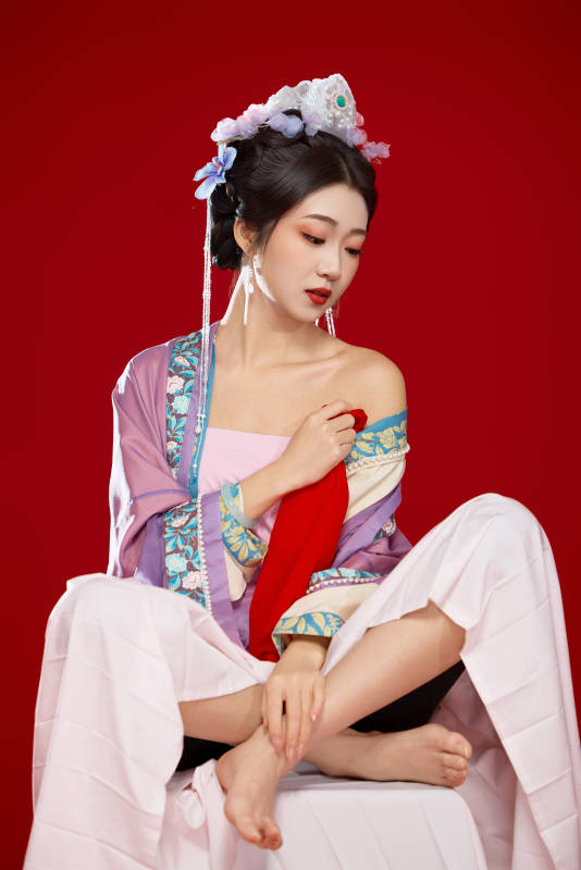 红色背景下身穿中国明朝簪花发饰汉服的美女图片