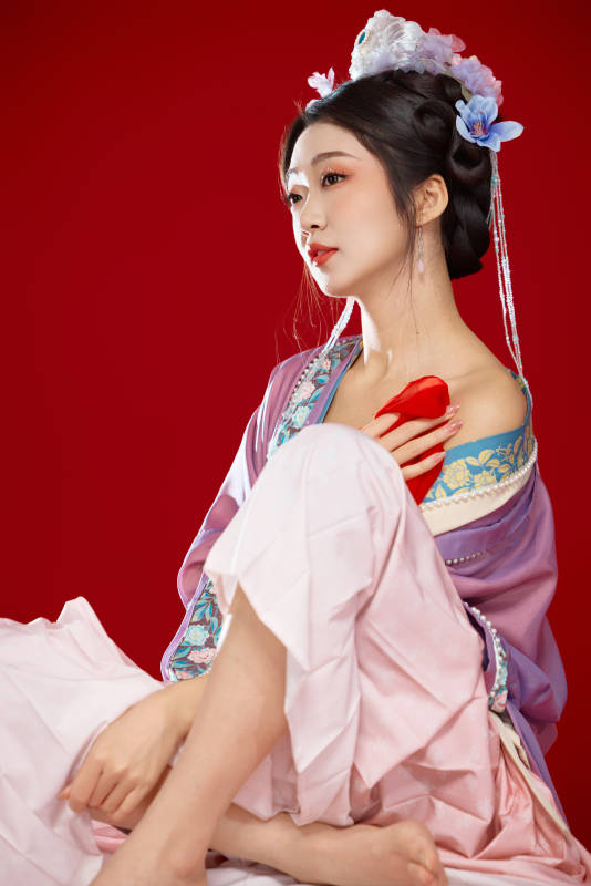 红色背景下身穿中国明朝簪花发饰汉服的美女图片