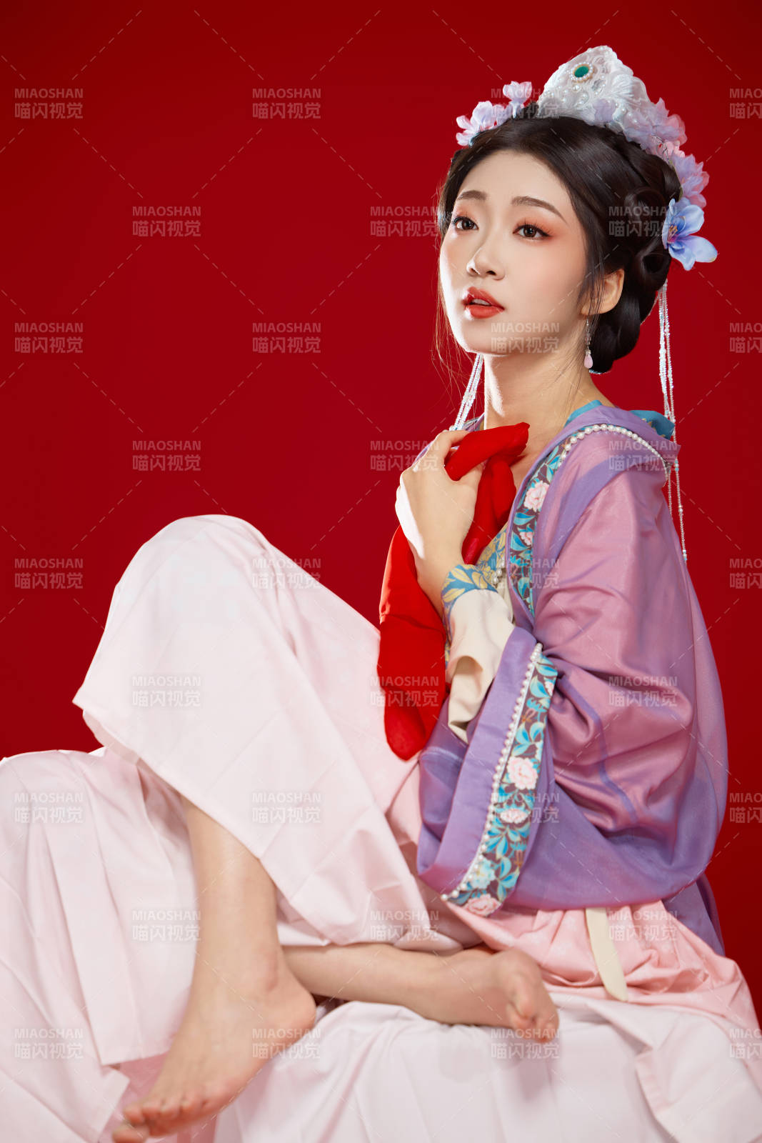 红色背景下身穿中国明朝簪花发饰汉服的美女图片