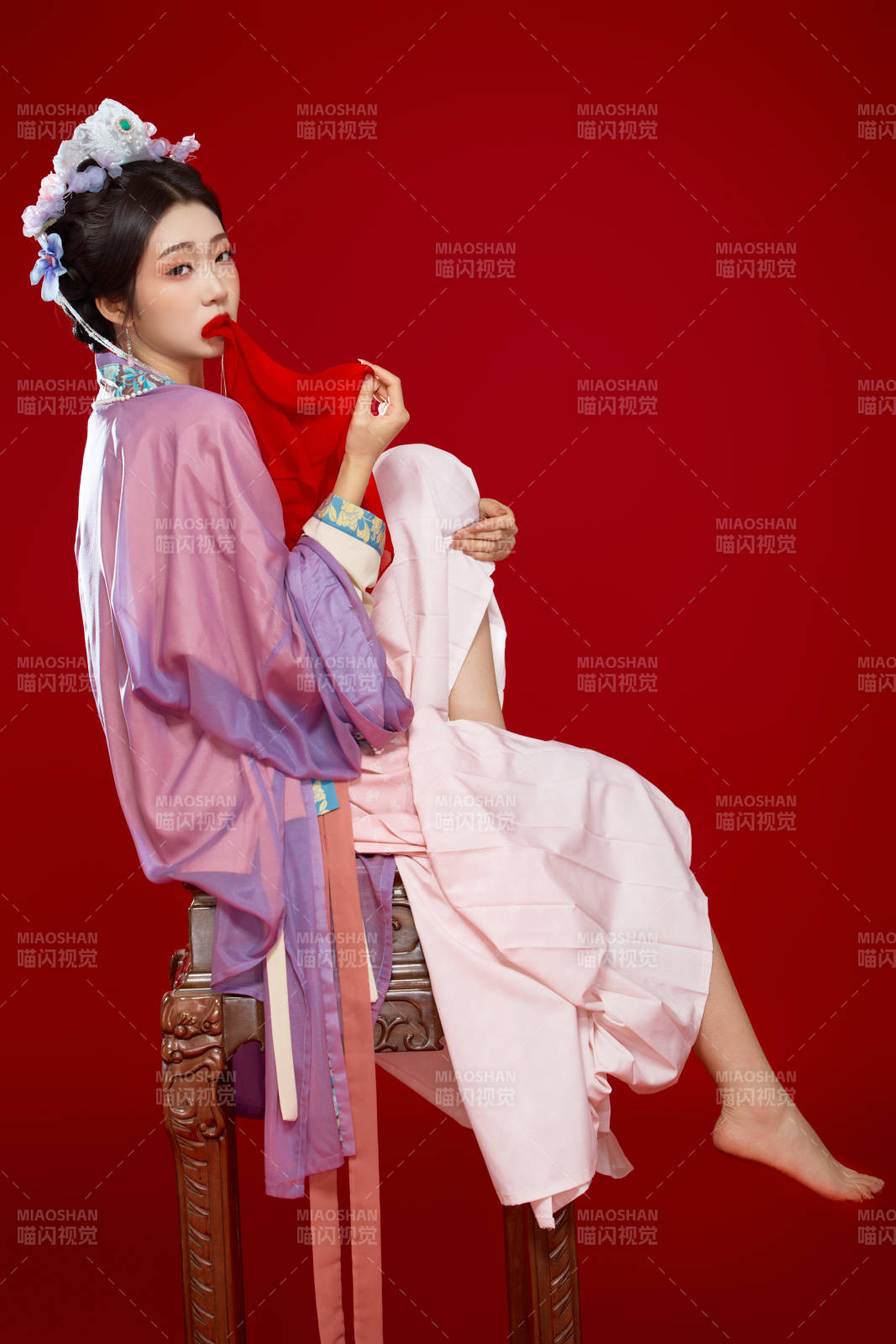 红色背景下身穿中国明朝簪花发饰汉服的美女图片