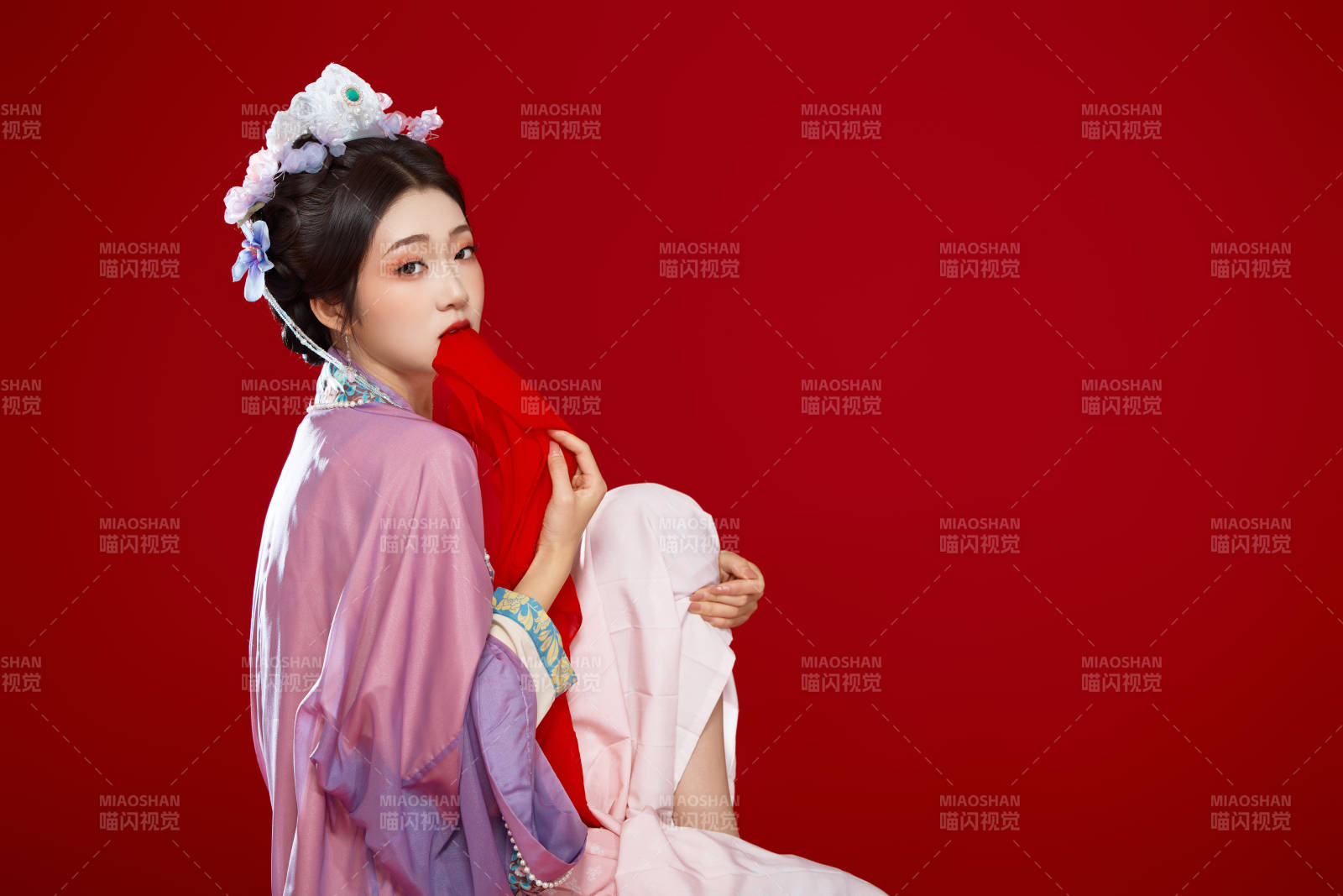 红色背景下身穿中国明朝簪花发饰汉服的美女图片