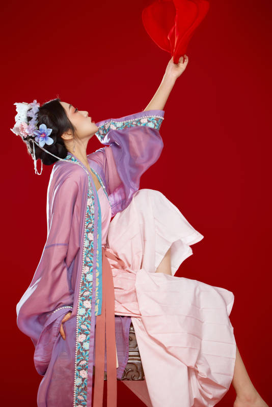 红色背景下身穿中国明朝簪花发饰汉服的美女图片