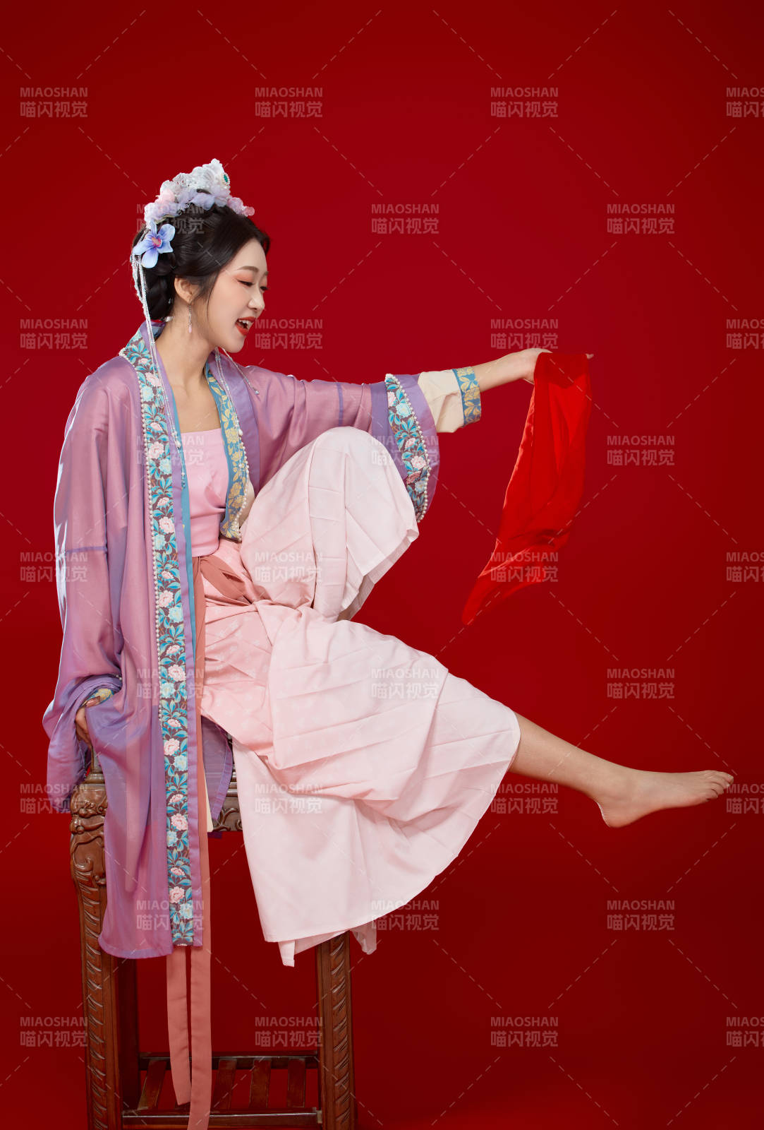红色背景下身穿中国明朝簪花发饰汉服的美女图片