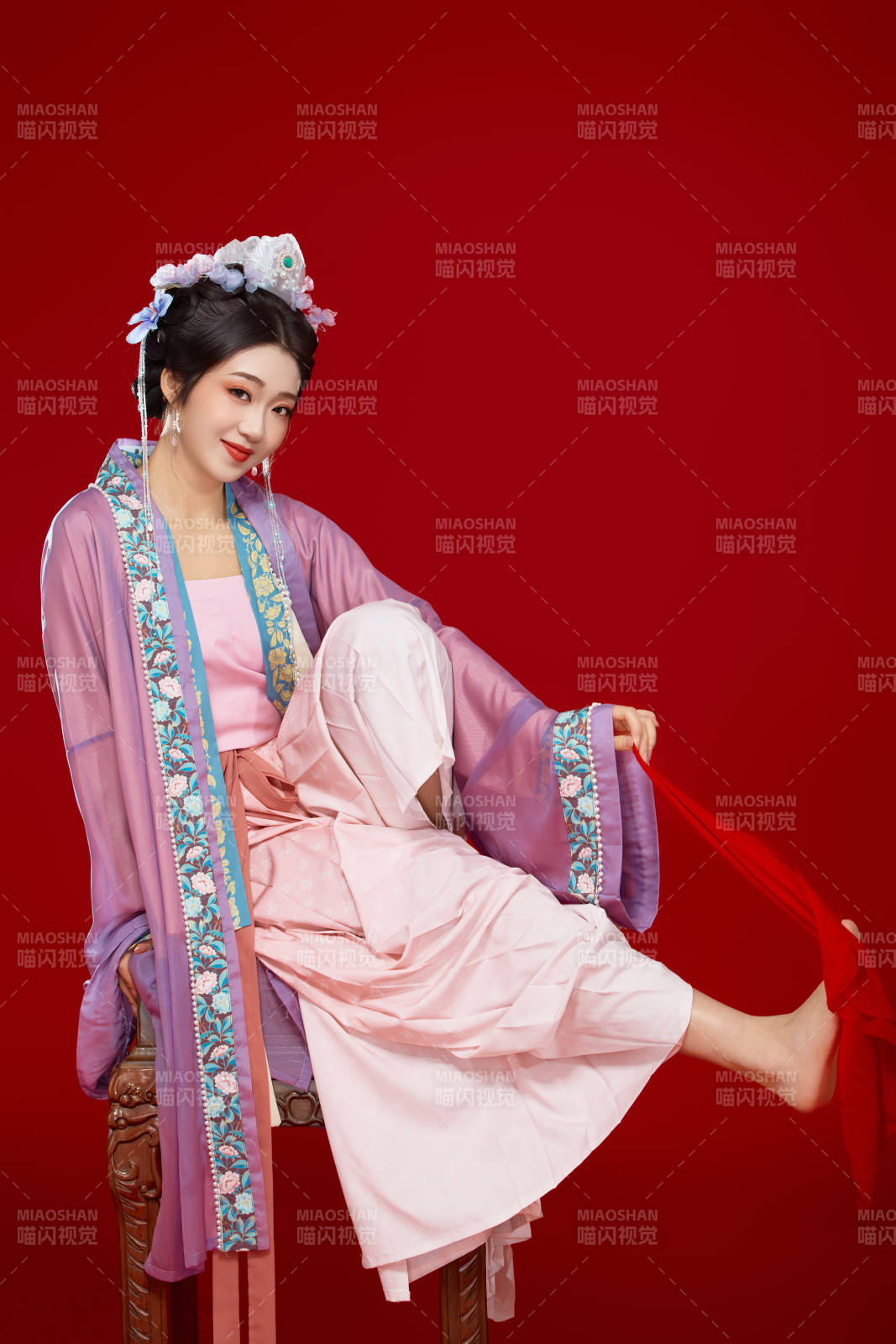 红色背景下身穿中国明朝簪花发饰汉服的美女图片