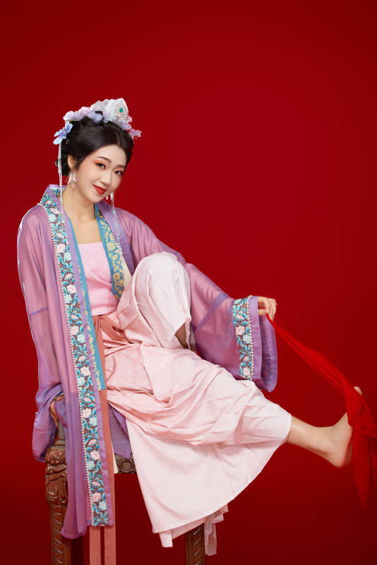 红色背景下身穿中国明朝簪花发饰汉服的美女图片