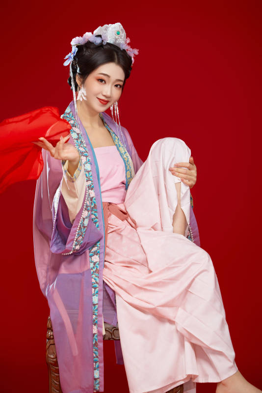 红色背景下身穿中国明朝簪花发饰汉服的美女图片