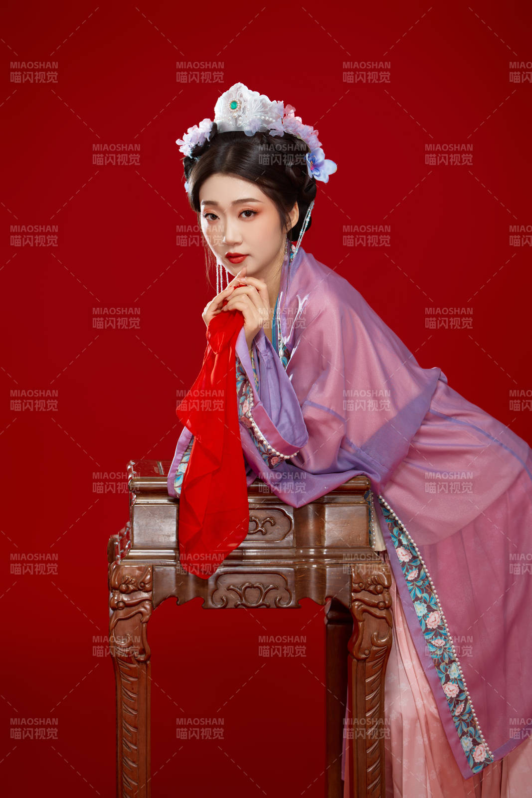 红色背景下身穿中国明朝簪花发饰汉服的美女图片