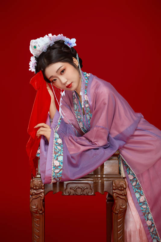 红色背景下身穿中国明朝簪花发饰汉服的美女图片