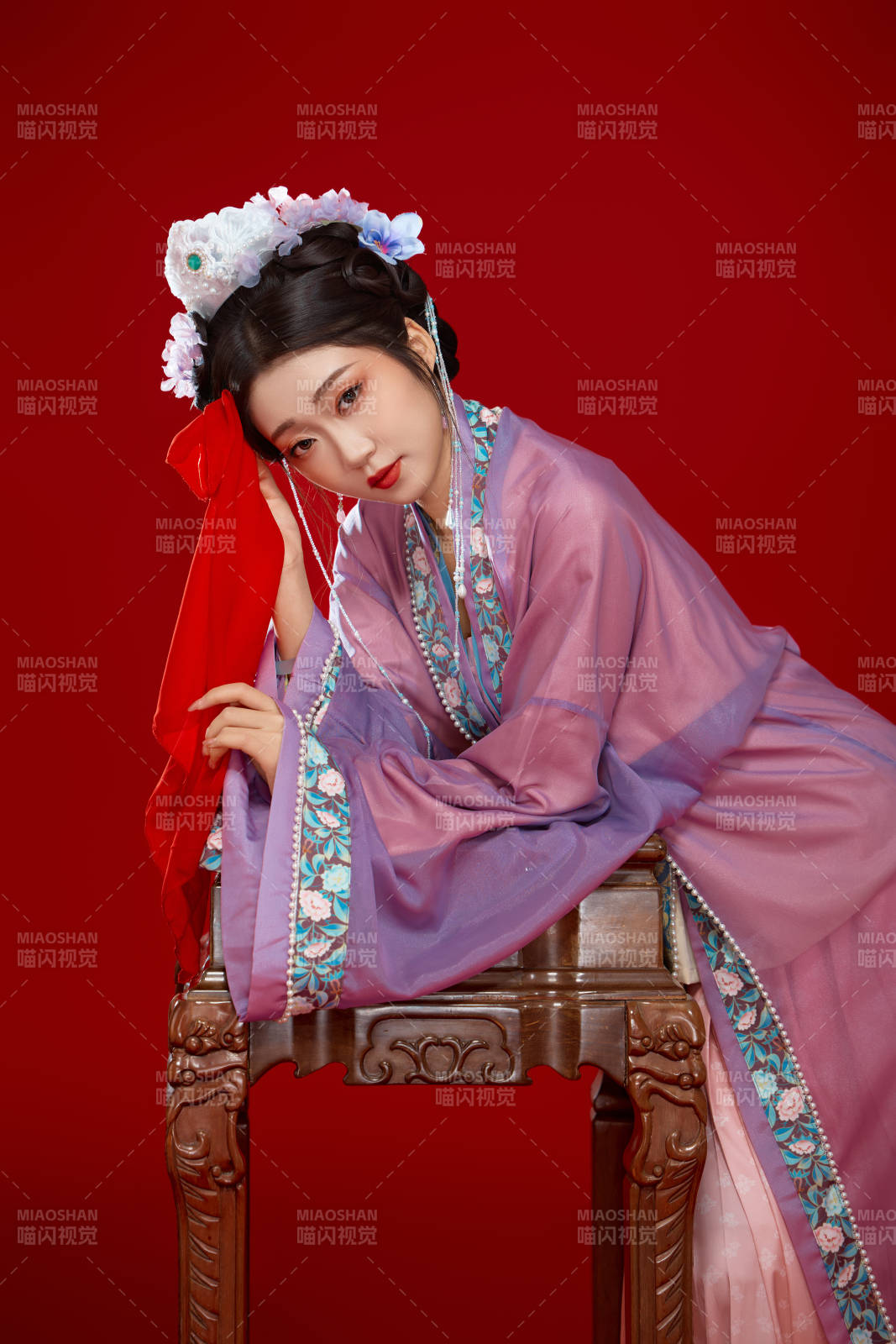 红色背景下身穿中国明朝簪花发饰汉服的美女图片