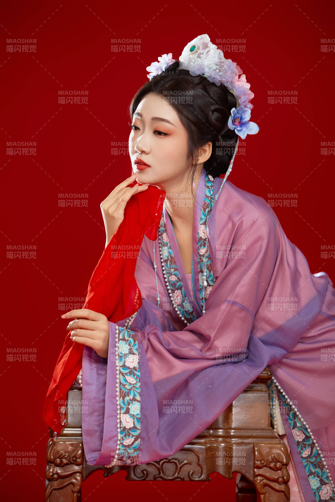 红色背景下身穿中国明朝簪花发饰汉服的美女图片