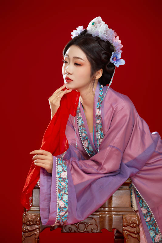 红色背景下身穿中国明朝簪花发饰汉服的美女图片