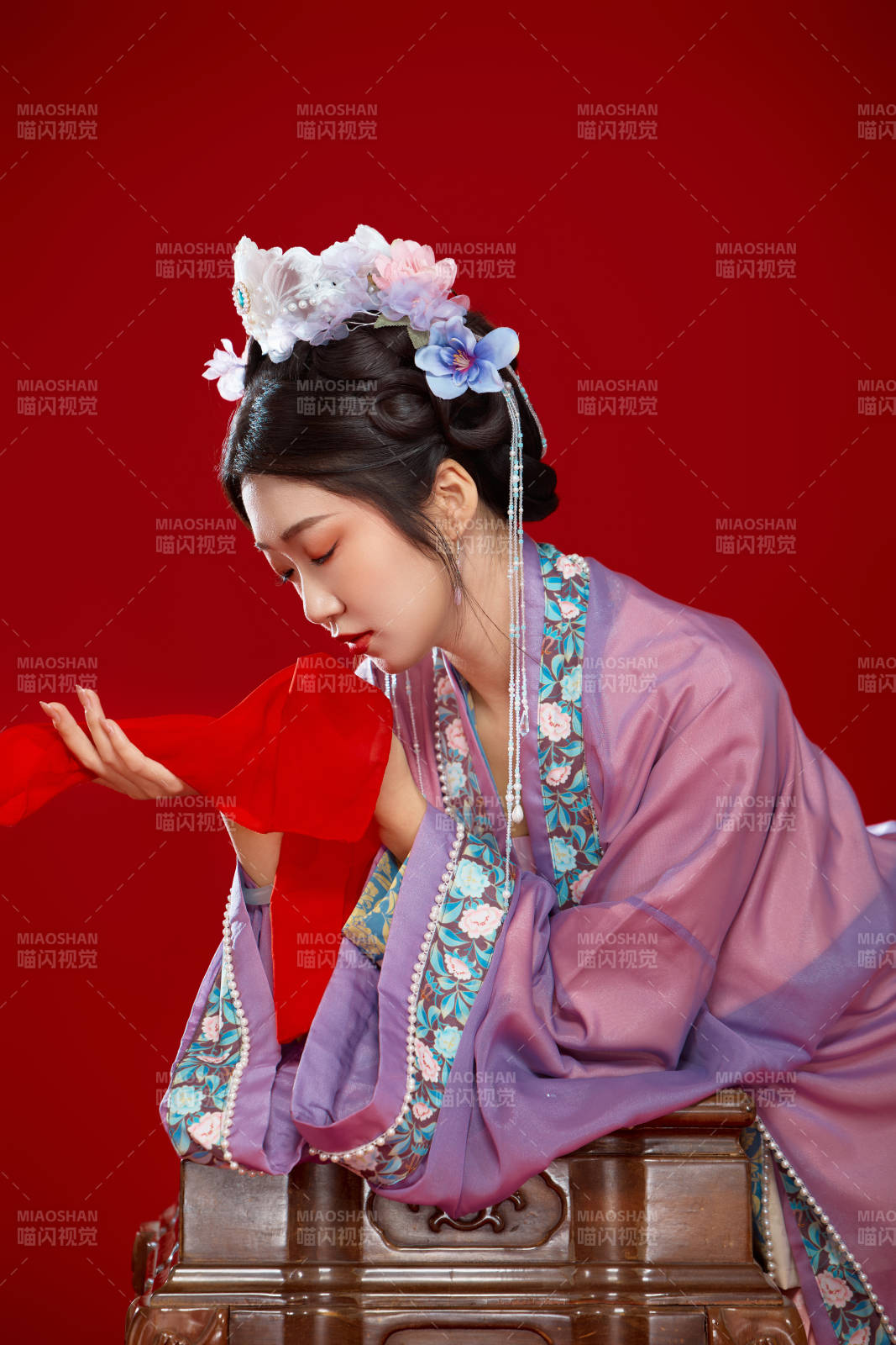 红色背景下身穿中国明朝簪花发饰汉服的美女图片