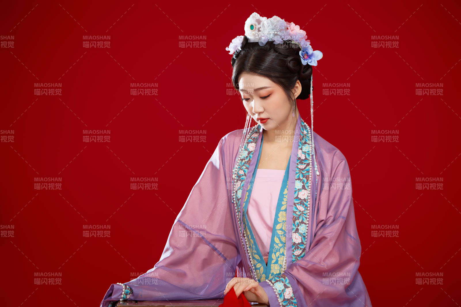 红色背景下身穿中国明朝簪花发饰汉服的美女图片