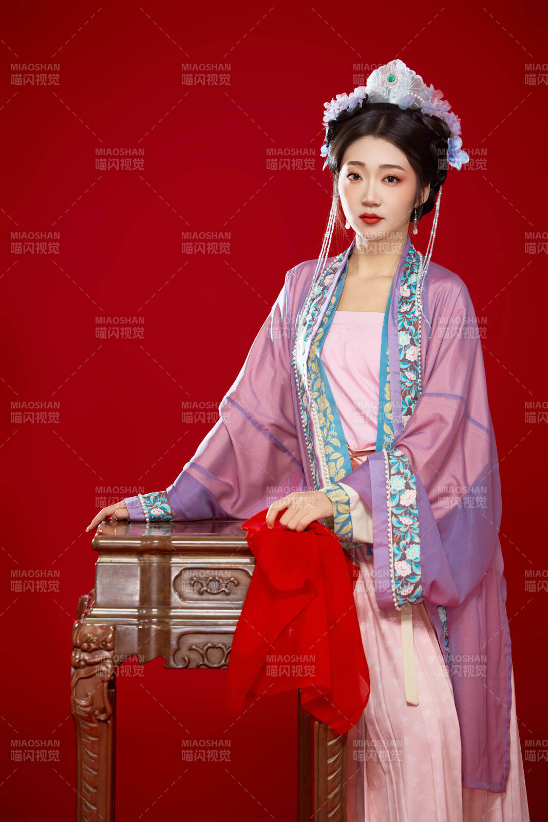 红色背景下身穿中国明朝簪花发饰汉服的美女图片