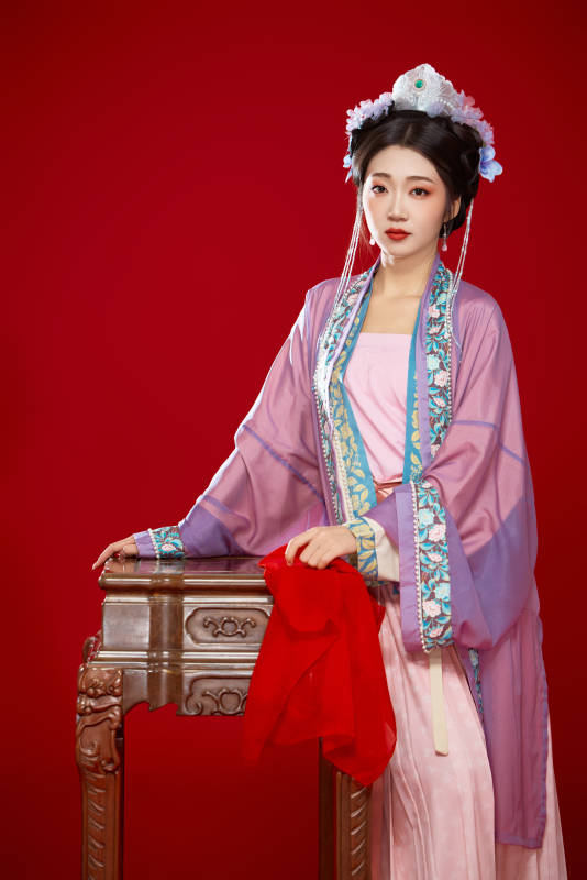 红色背景下身穿中国明朝簪花发饰汉服的美女图片