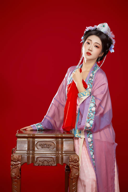 红色背景下身穿中国明朝簪花发饰汉服的美女图片