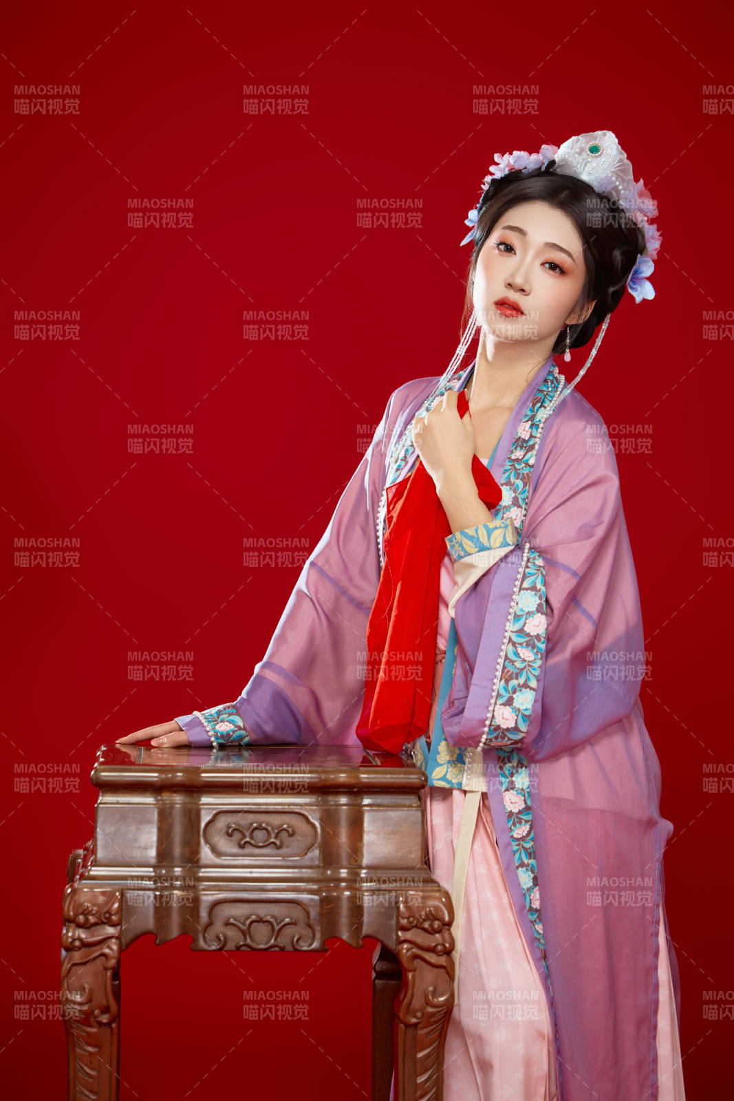 红色背景下身穿中国明朝簪花发饰汉服的美女图片