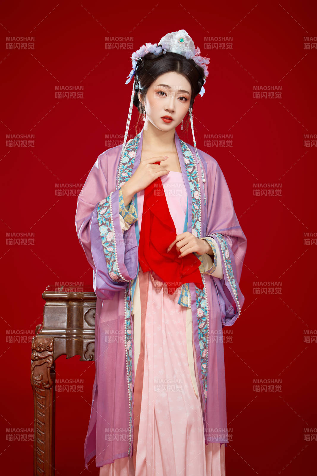 红色背景下身穿中国明朝簪花发饰汉服的美女图片