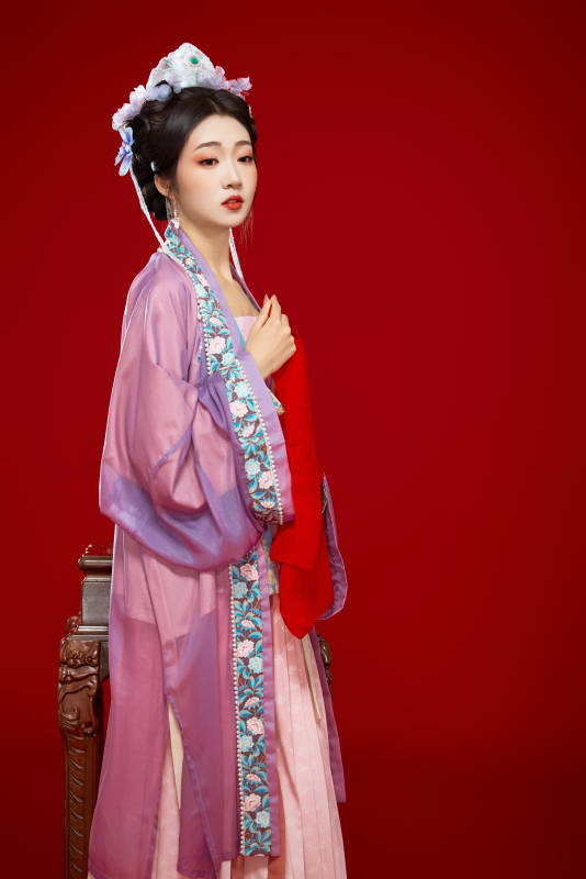 红色背景下身穿中国明朝簪花发饰汉服的美女图片