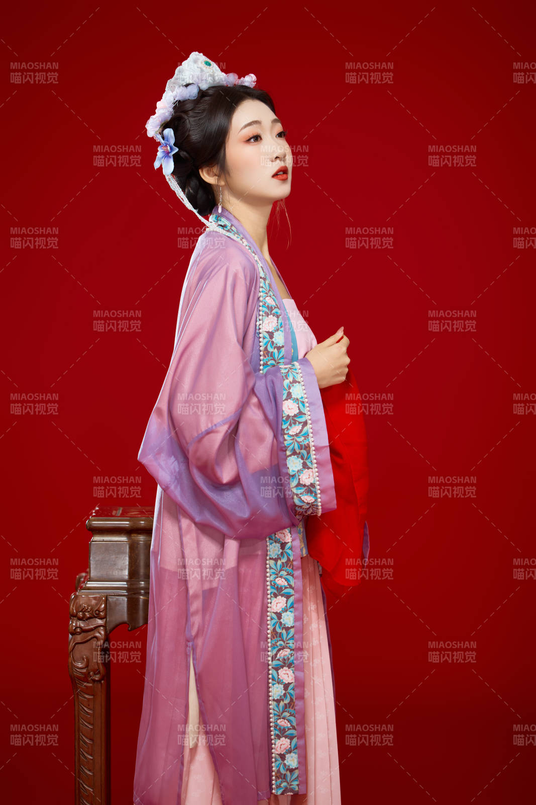 红色背景下身穿中国明朝簪花发饰汉服的美女图片