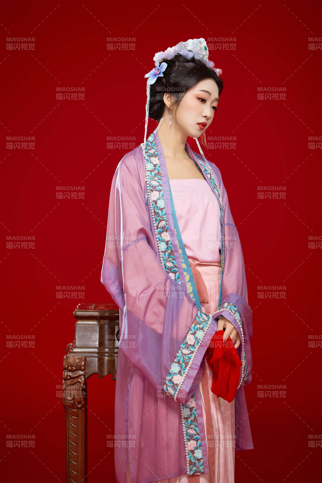 红色背景下身穿中国明朝簪花发饰汉服的美女图片