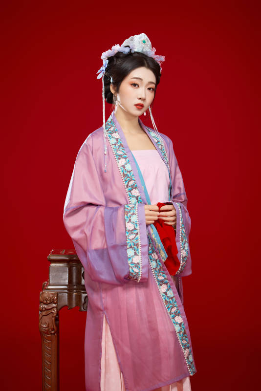 红色背景下身穿中国明朝簪花发饰汉服的美女图片