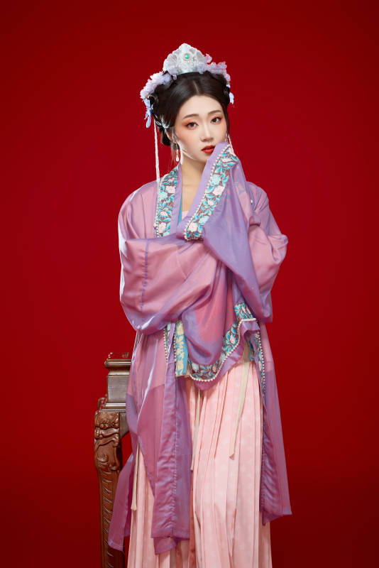 红色背景下身穿中国明朝簪花发饰汉服的美女图片