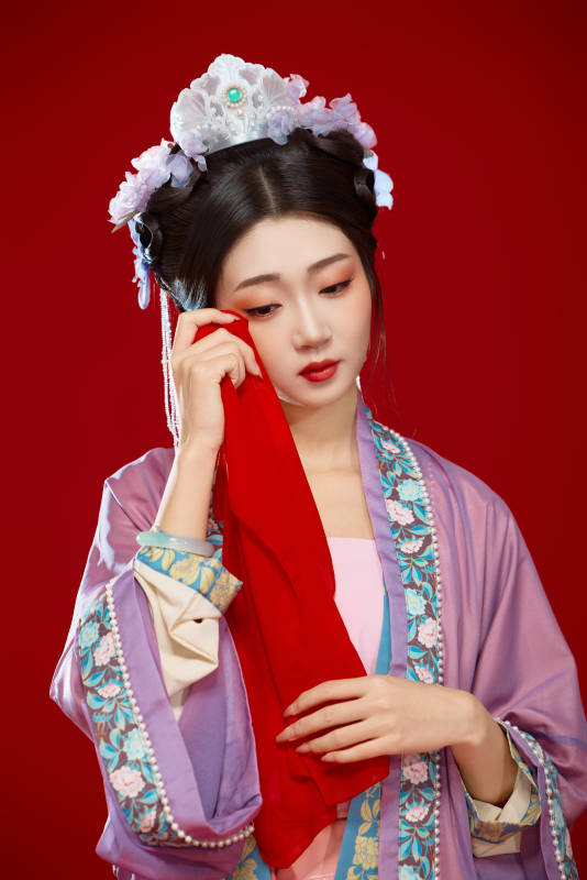 红色背景下身穿中国明朝簪花发饰汉服的美女图片