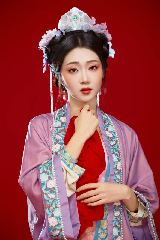 红色背景下身穿中国明朝簪花发饰汉服的美女图片