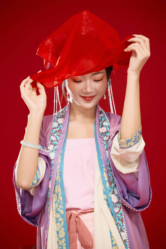 红色背景下身穿中国明朝簪花发饰汉服的美女图片