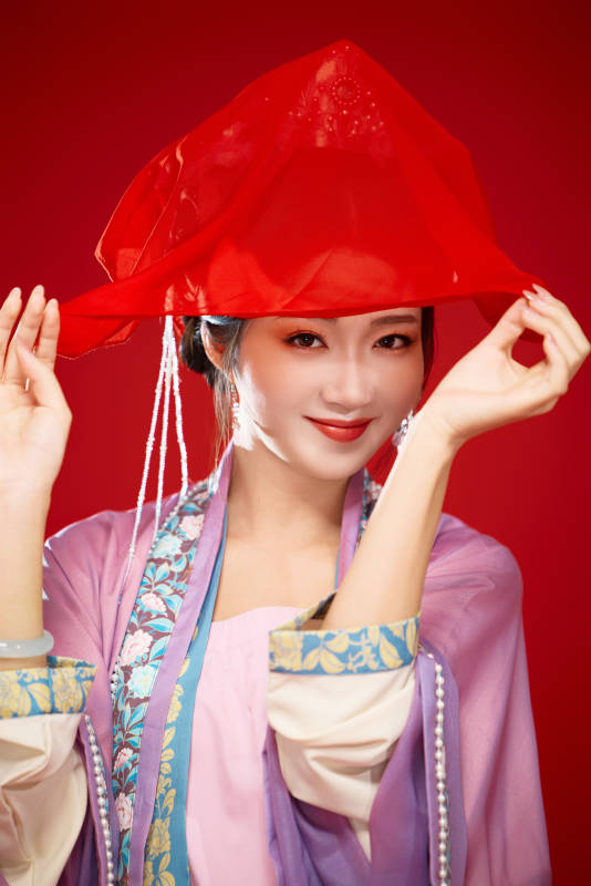 红色背景下身穿中国明朝簪花发饰汉服的美女图片