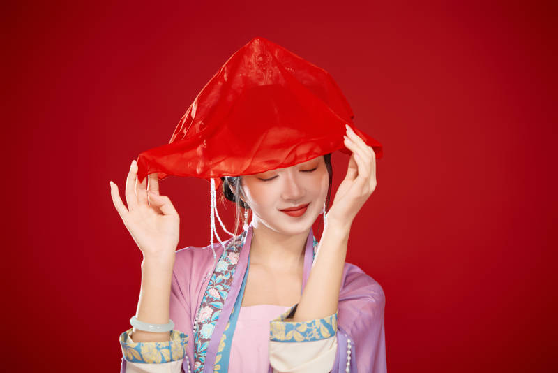 红色背景下身穿中国明朝簪花发饰汉服的美女图片