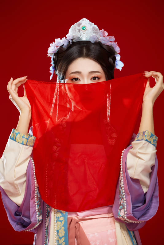 红色背景下身穿中国明朝簪花发饰汉服的美女图片