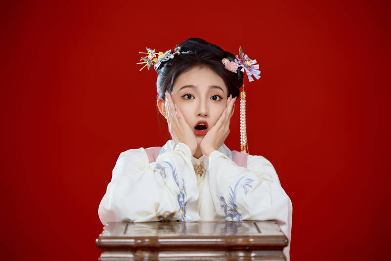 红色背景下穿着中国明朝明制汉服服饰的少女图片